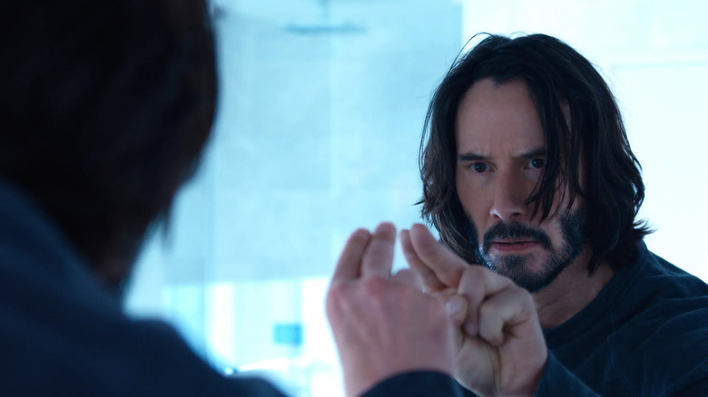 Neo poking a mirror in The Matrix Resurrections