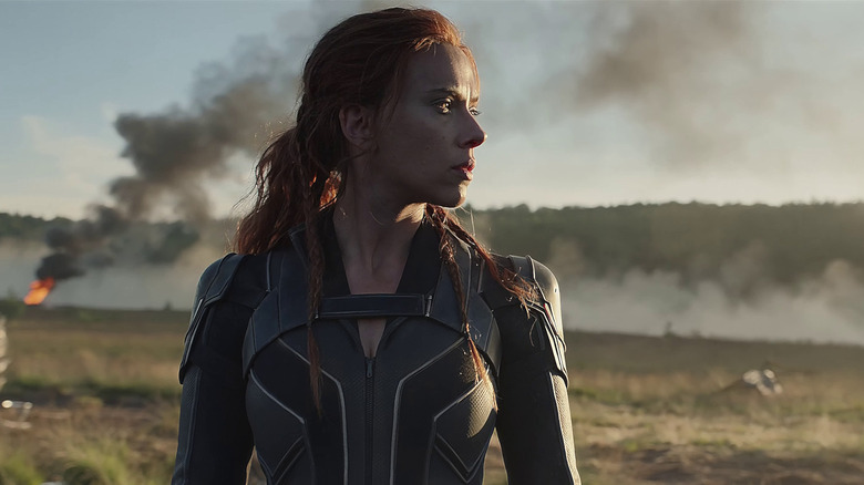Black Widow looks out across a field in "Black Widow" (2021)