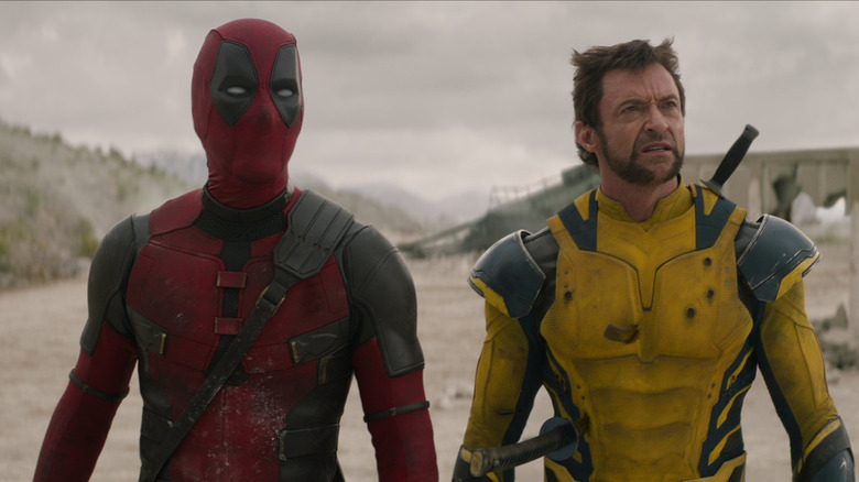 Deadpool and Wolverine stand side by side on a battlefield in "Deadpool and Wolverine" (2024)