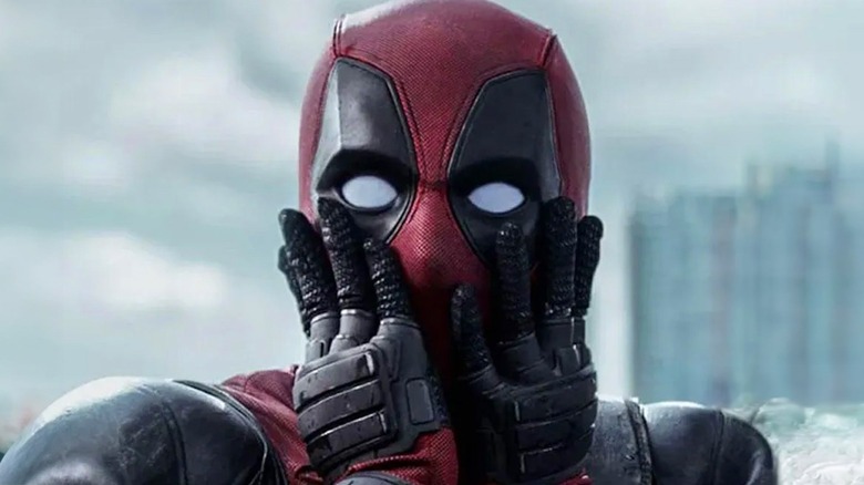 A shocked Deadpool holding his masked face in "Deadpool"