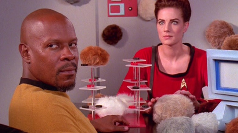 Captain Sisko and Jadzia Dax at a tribble-filled table in "Trials and Tribble-ations"