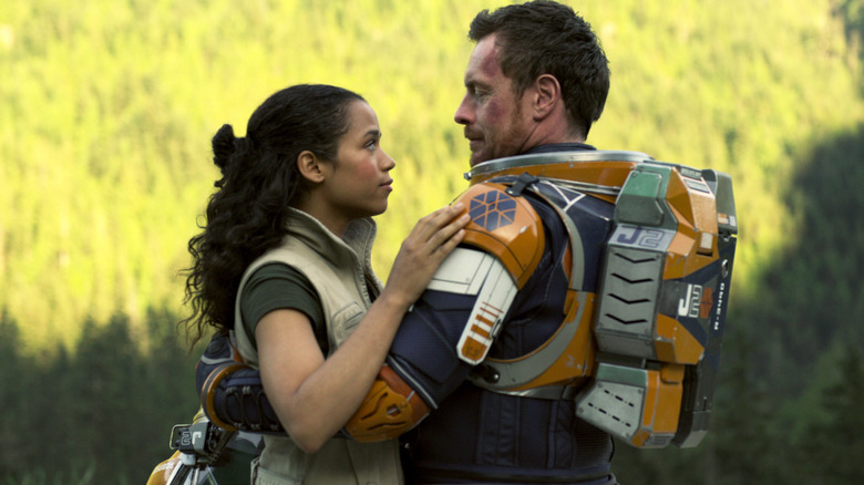 John Robinson wearing a jet pack and holding Judy Robinson in "Lost in Space" (2018)