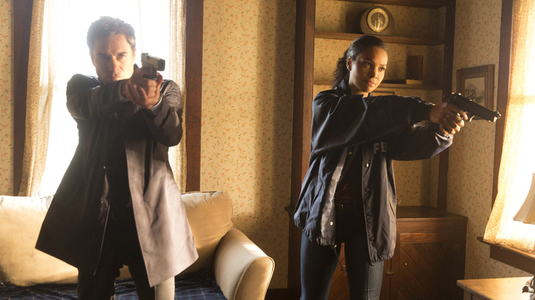 Grant and Carly pointing guns in "Travelers" (2016)