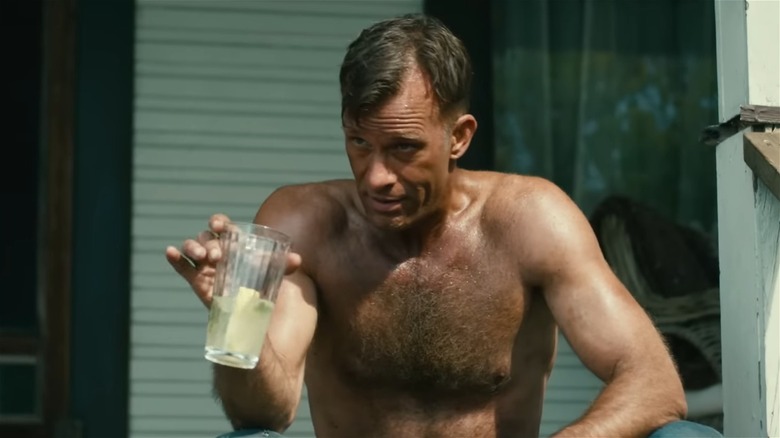Thomas Jane as Wilfred in 1922, shirtless and holding a glass of lemonade