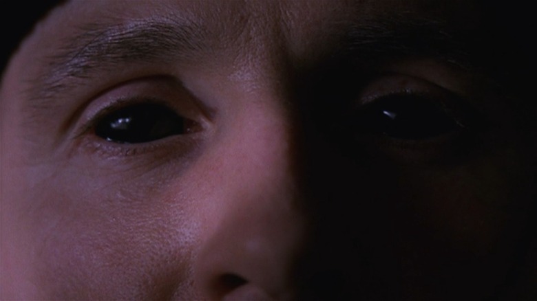 An extreme closeup of Colm Feore as Andre Linoge with pitch-black eyes, in Storm of the Century