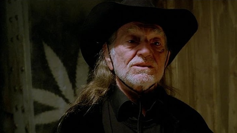 Willie Nelson standing in front of flag in "Beerfest"