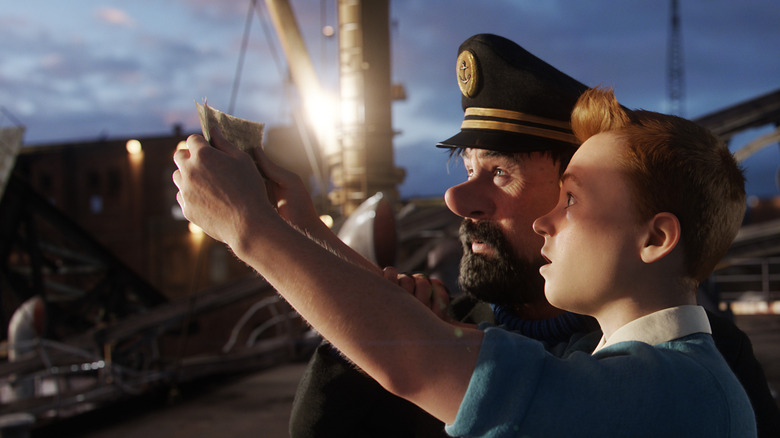 Tintin wears a blue shirt with orange hair while holding up a map to Captain Haddock wearing a captain's hat in "The Adventures of Tintin"