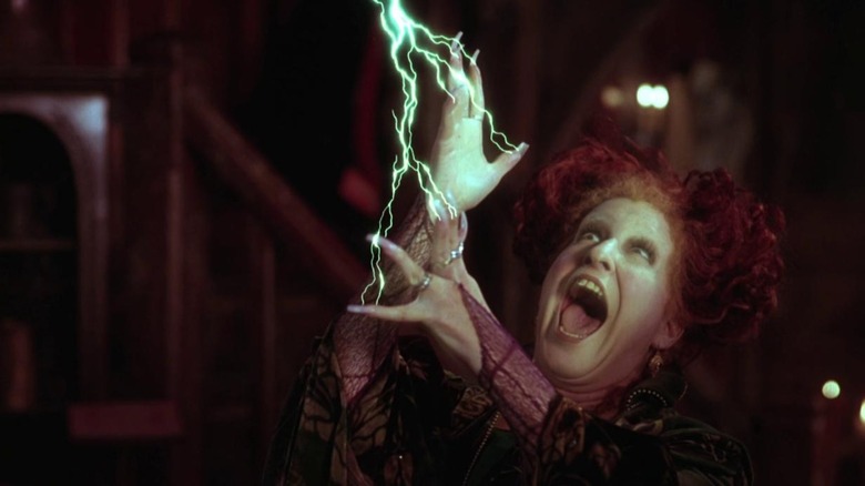 Bette Midler as Winifred Sanderson in Hocus Pocus, cackling while lightning shoots from her fingers