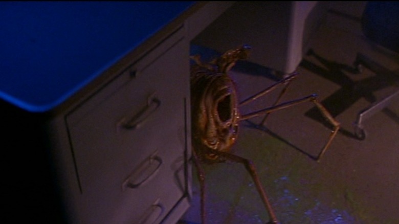 A wet-looking spider-creature under the desk in The Thing