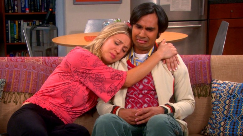 Penny comforting a crying Raj on a couch in 