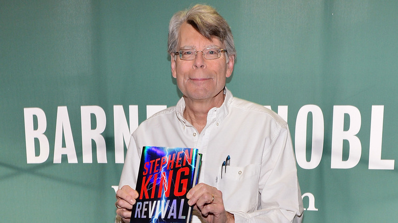 Stephen King holding his book 
