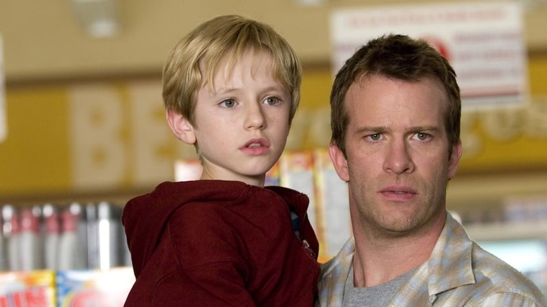 David carries his child through the grocery story in Stephen King's The Mist (2007)