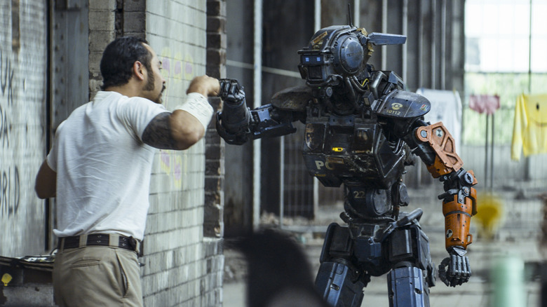 Chappie givng a human a fist-bump in Chappie (2015)