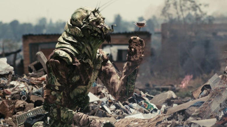 Wikus as a Prawn making a metal flower in District 9 (2009)