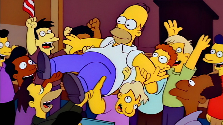 Homer being lifted up by his coworkers on "The Simpsons"