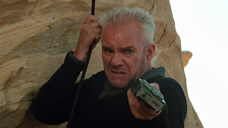 Tolian Soran hanging from a cliff and pointing a remote control in "Star Trek: Generations"