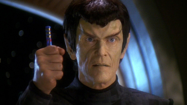 Senator Vreenak holds up a Cardassian data rod in Star Trek: Deep Space Nine