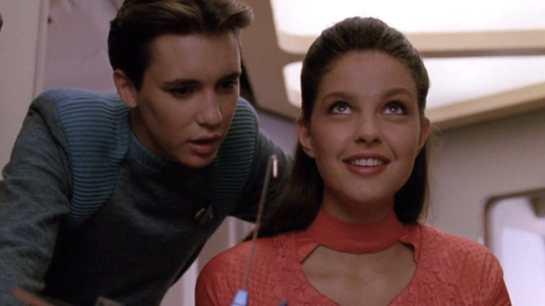 Ensign Lefler stands in engineering smiling in Star Trek: The Next Generation
