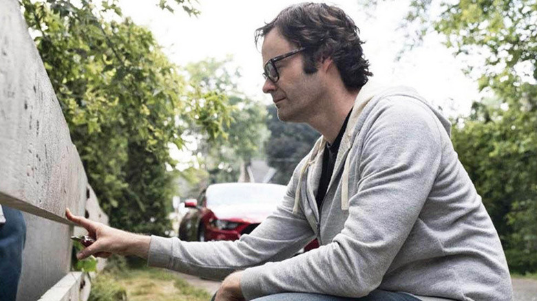 Richie Tozier looking at carvings in a piece of wood in "It: Chapter Two"