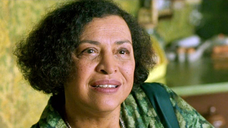 The Oracle wears a green dress while sitting in her green kitchen in "The Matrix"