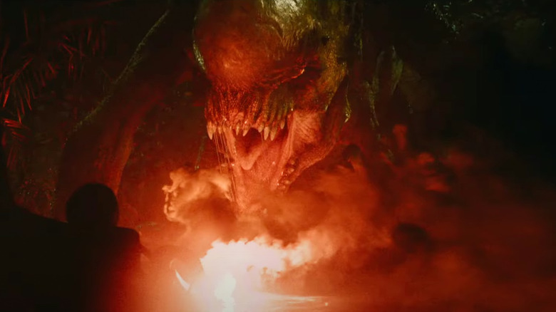The Distortus rex roars in front of a glowing red flare in "Jurassic World: Rebirth"