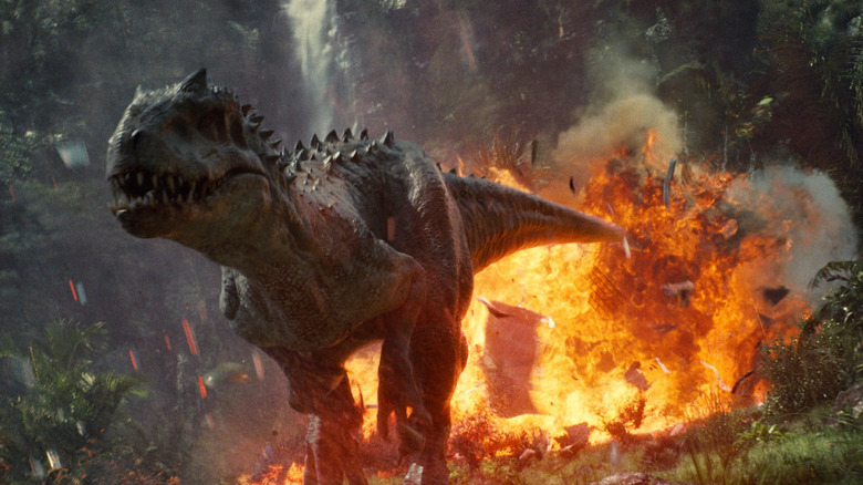 The Indominous rex runs away from a firey explosion in "Jurassic World"