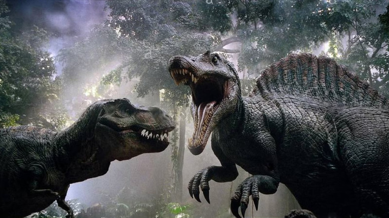 The Spinosaurus raors in the face of a Tyrannosaurus rex surrounded by mist and jungle trees in "Jurassic Park 3"