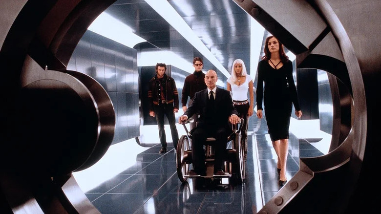 Wolverine, Cyclops, Charles Xavier, Storm, and Jean Grey in a brightly-lit corridor in X-Men
