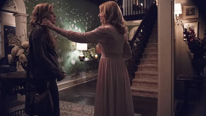 Adora touching Camille's hair in the hallway of her house on Sharp Objects