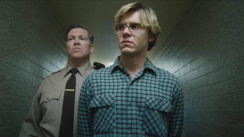 Dahmer being walked down a hallway by a police officer on Dahmer – Monster: The Jeffrey Dahmer Story