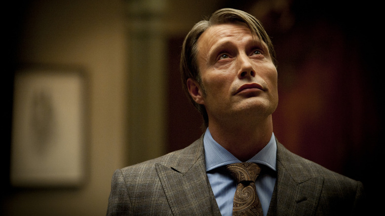 Hannibal looking up with a smirk on his face in Hannibal