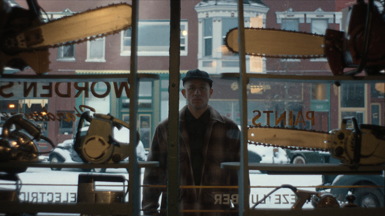 Ed Gein looking at chainsaws in a shop window on Monster: The Ed Gein Story