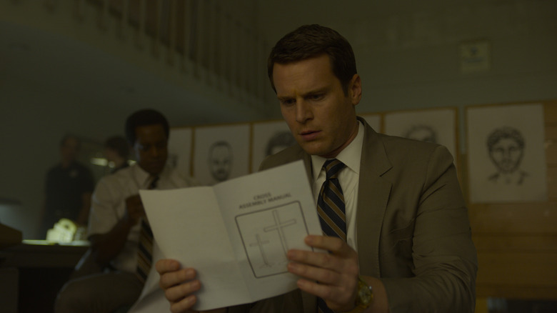 Holden reading a pamphlet shocked on Mindhunter
