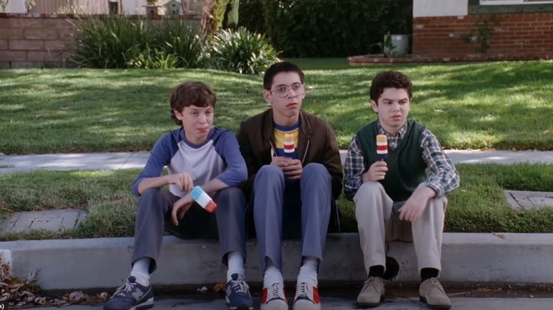 Sam Weir, Bill Haverchuck, and Neal Schweiber sit on the curb eating popsicles in "Freaks and Geeks"