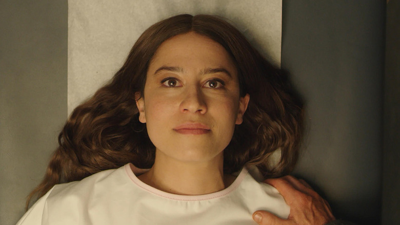 Lucy lying down for her doctor in "False Positive" (2021)
