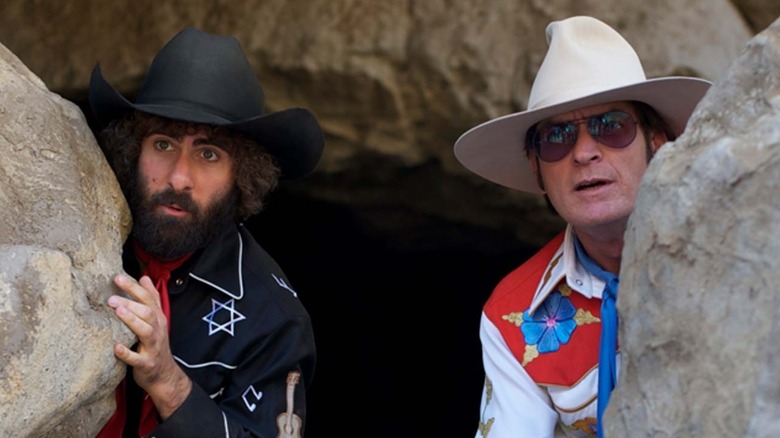 Kirby Star and Charles Swan III hide behind a rock in 