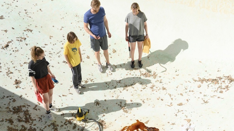 The Waller family inspecting their drained pool in Night Swim (2024)