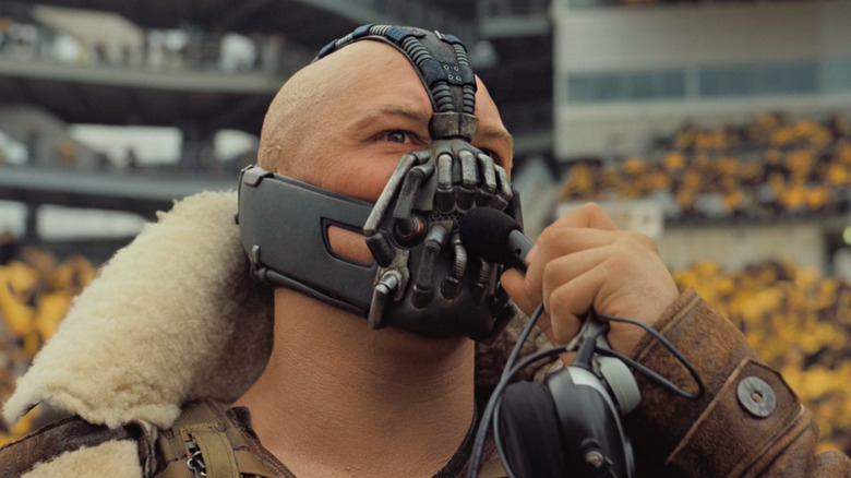 Bane speaking to his crew via wired microphone in The Dark Knight Rises (2012)