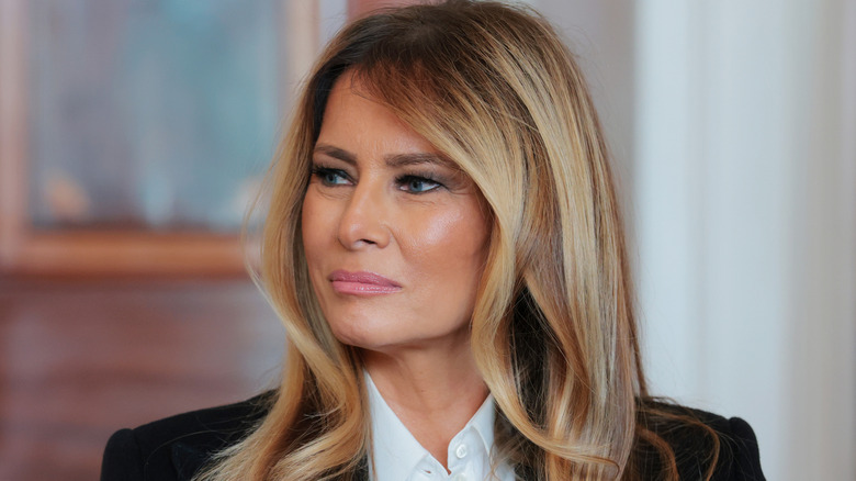 Melania Trump smiling in a black blazer