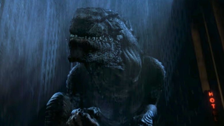 Godzilla (in name only) examining a human in Godzilla