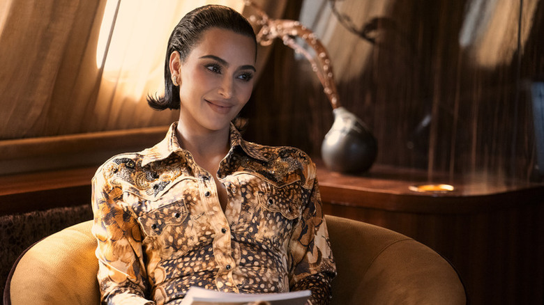 Allura with her hair slicked back smirking and sitting back in a chair in All's Fair