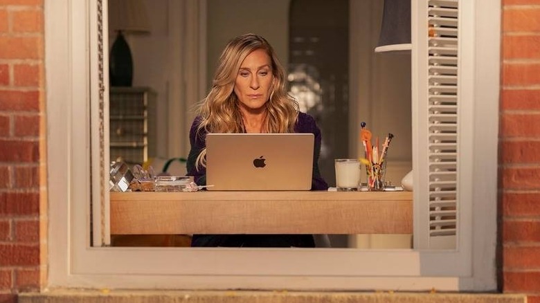 Carrie looking at her laptop in her living room in And Just Like That