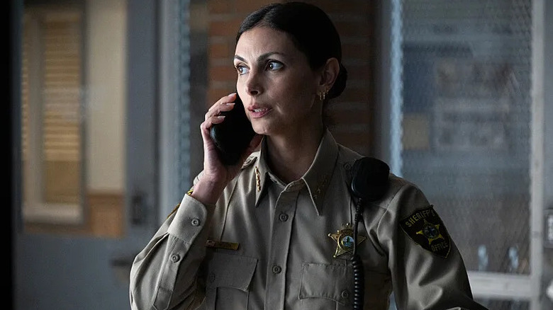 Mickey on the phone in uniform looking shocked on Sheriff Country