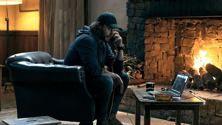 Ben on the phone in front of a fire in The Terminal List: Dark Wolf