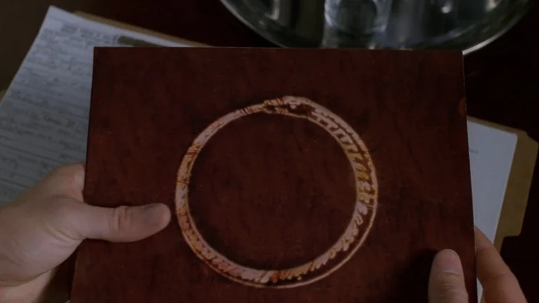 Hands holding a Millennium Group folder on The X-Files (1993-2018)