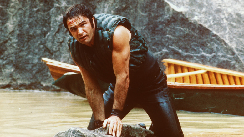 Burt Reynolds' Lewis Medlock pressing down on a rock in Deliverance