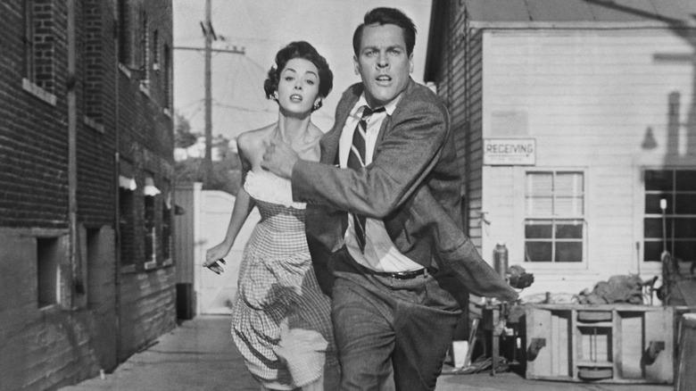 Becky and Miles running down an alley in Invasion of the Body Snatchers (1956)