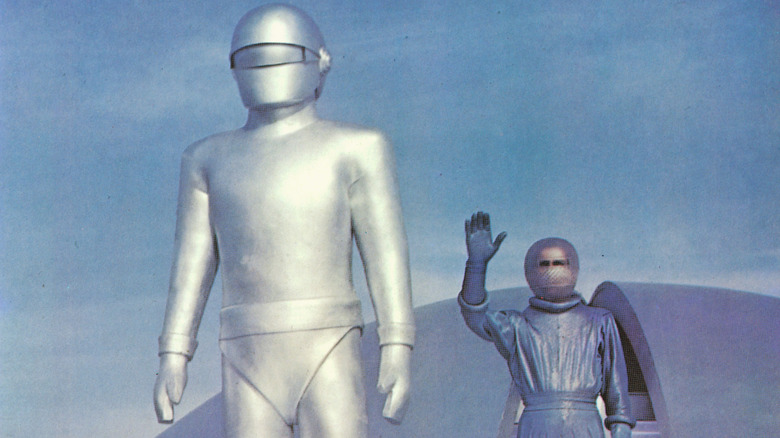 Two aliens in spacesuits, one waving, in The Day the Earth Stood Still (1951)