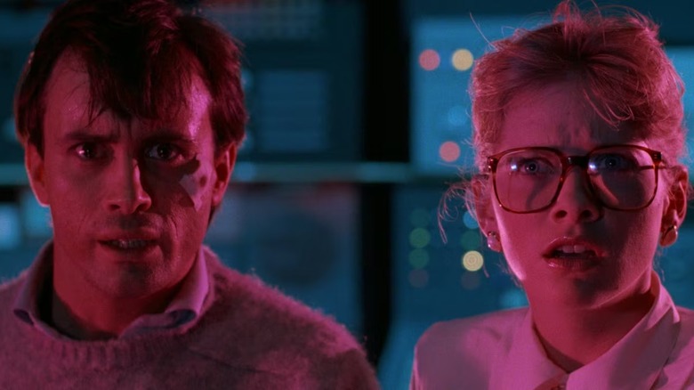 Dr McMichaels and Tillinghast are lit in magenta and staring in From Beyond