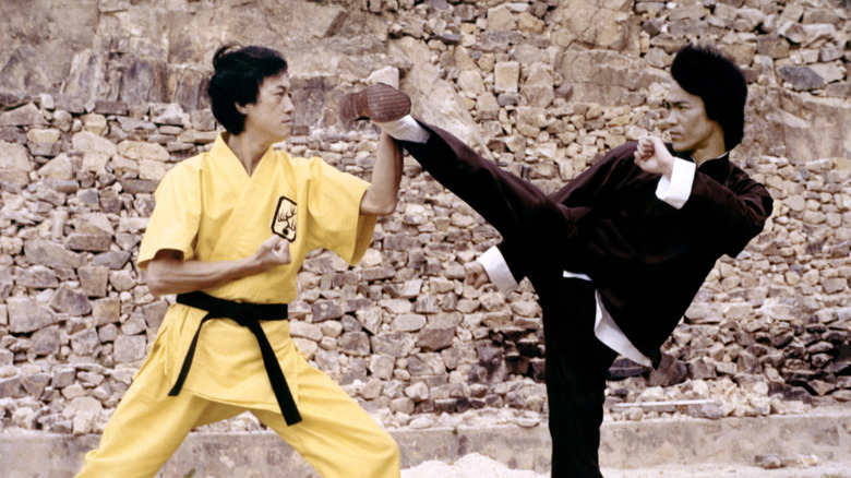An opponent blocks Lee's kick in "Enter the Dragon" (1973)